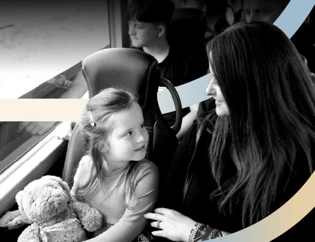 Child on bus with teddy bear and parent/guardian